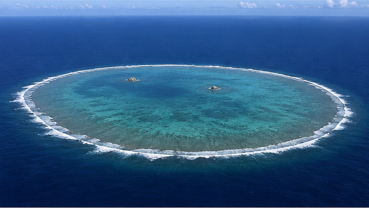 海面すれすれに広がる沖ノ鳥島のサンゴ礁と、わずかに露出した小島